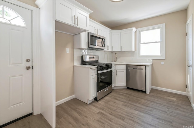 kitchen with white cabinets, a wealth of natural light, and appliances with stainless steel finishes