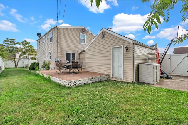 rear view of house with a yard and a deck