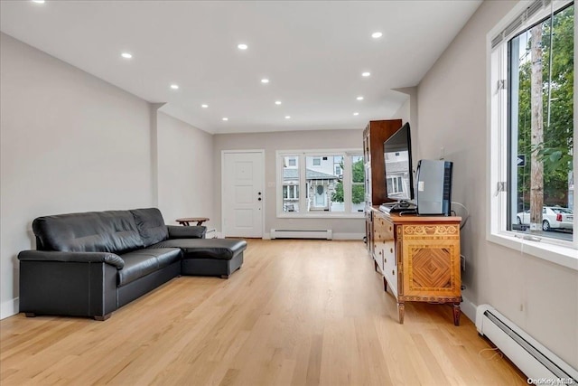 living room with baseboard heating and light hardwood / wood-style floors