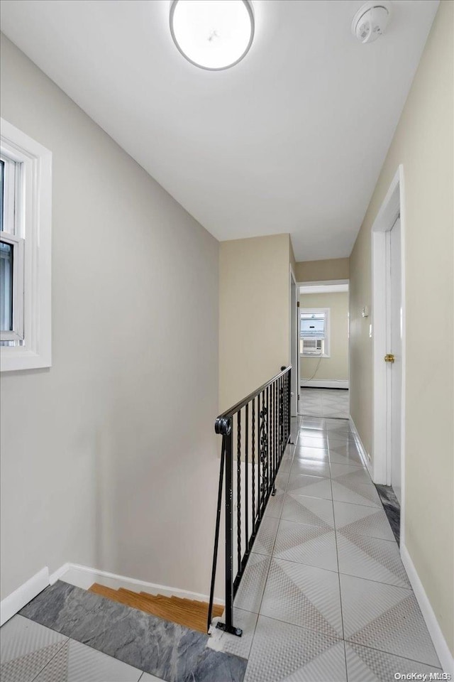 corridor with a healthy amount of sunlight and light tile patterned floors