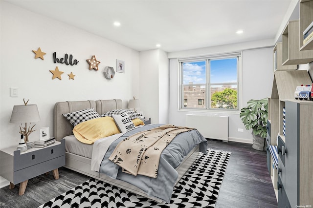 bedroom with radiator heating unit and dark wood-type flooring