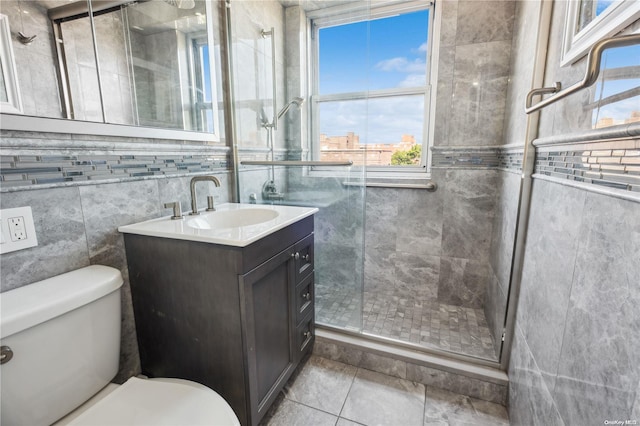 bathroom featuring vanity, tile patterned floors, toilet, tile walls, and walk in shower