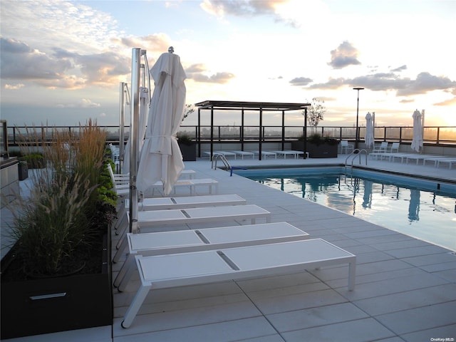 pool at dusk with a patio