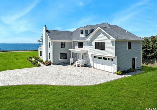 view of front of home featuring a garage, a water view, and a front yard