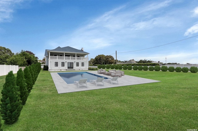 back of property featuring a lawn, a patio, and a fenced in pool