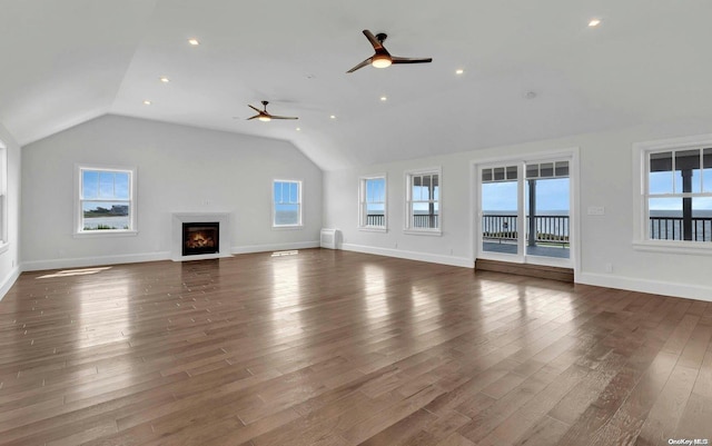 unfurnished living room with dark hardwood / wood-style floors, a healthy amount of sunlight, and vaulted ceiling