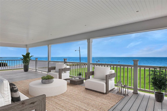 wooden deck with a yard, a water view, and a beach view