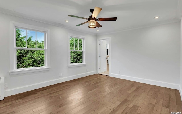 spare room featuring hardwood / wood-style floors, plenty of natural light, ornamental molding, and ceiling fan