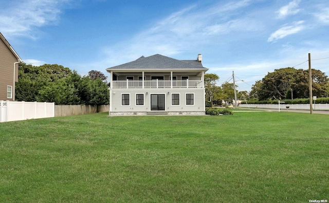 back of property featuring a yard and a balcony