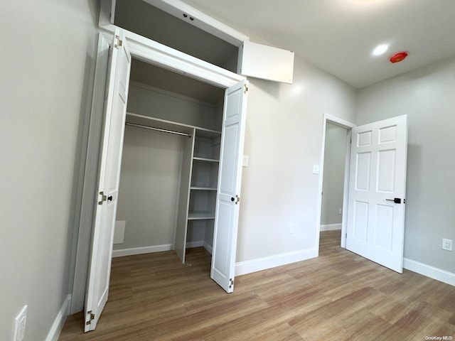 unfurnished bedroom with light hardwood / wood-style floors and a closet