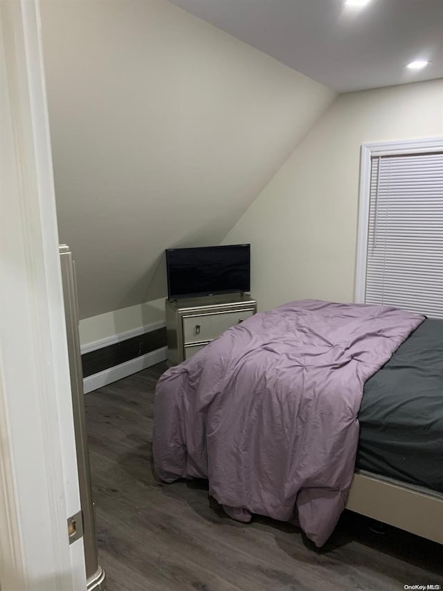 bedroom with vaulted ceiling and dark wood-type flooring