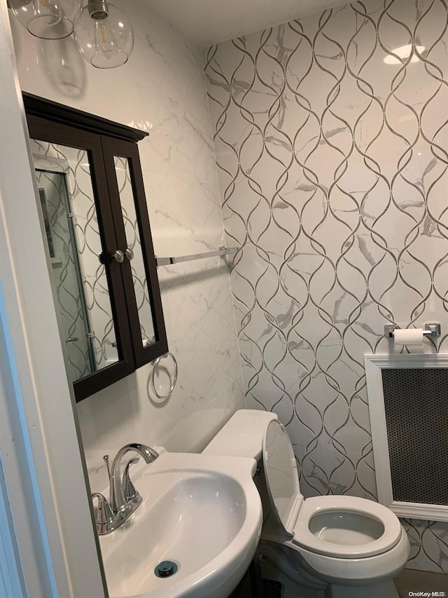 bathroom featuring radiator heating unit, toilet, and sink