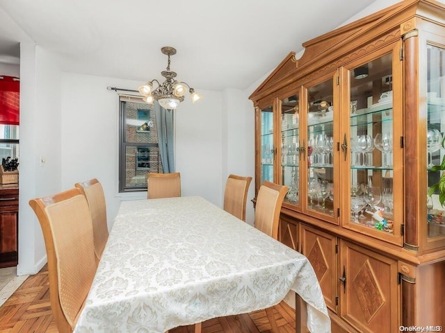 dining space featuring light parquet floors and a notable chandelier