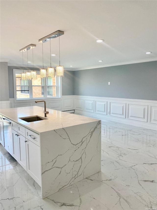 kitchen with white cabinetry, sink, light stone countertops, hanging light fixtures, and a kitchen island with sink