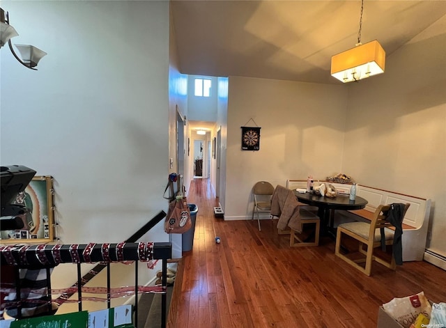 dining space with wood-type flooring and a high ceiling