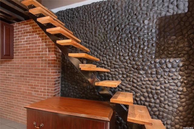 bar with light tile patterned floors and brick wall