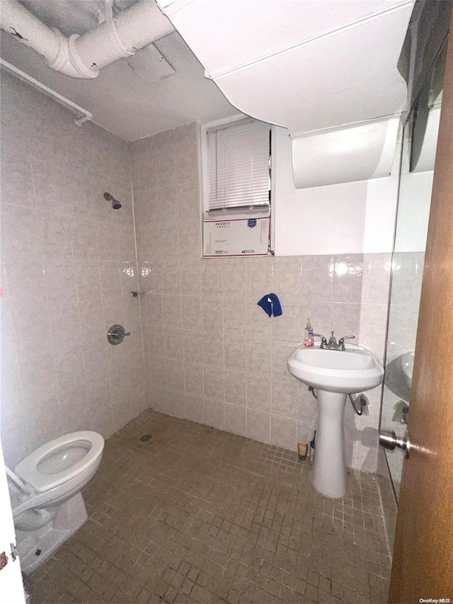 bathroom featuring toilet, tile patterned flooring, tile walls, and tiled shower