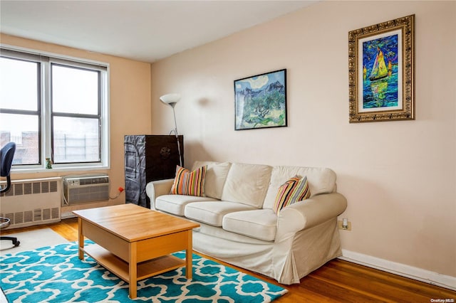 living room featuring hardwood / wood-style floors, radiator heating unit, and a wall mounted AC