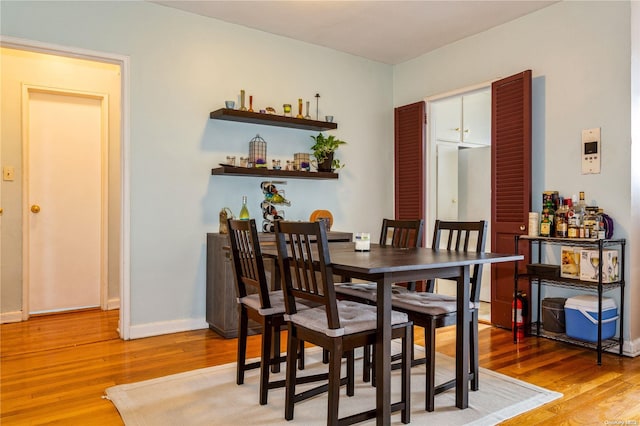 dining room featuring hardwood / wood-style floors and bar