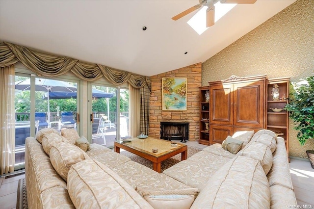 tiled living room with a stone fireplace, ceiling fan, and lofted ceiling