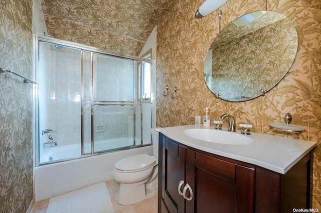 full bathroom with tile patterned floors, vanity, enclosed tub / shower combo, and toilet