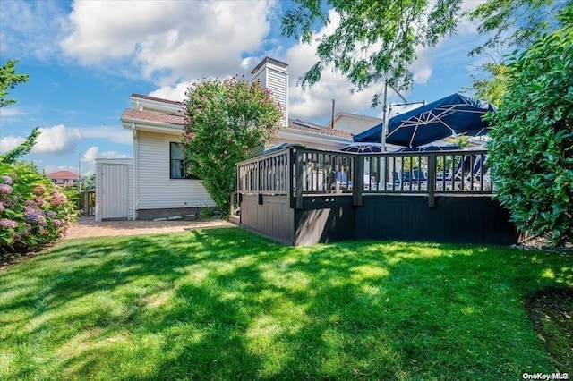 back of house with a yard and a wooden deck