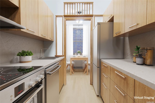 kitchen featuring decorative backsplash, appliances with stainless steel finishes, light wood-type flooring, exhaust hood, and sink