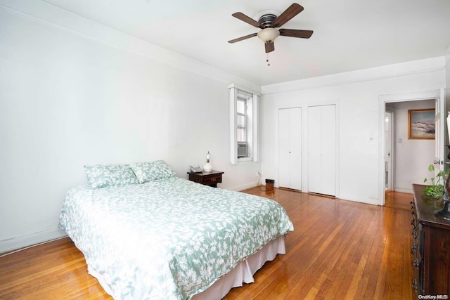 bedroom with ceiling fan, cooling unit, and wood-type flooring