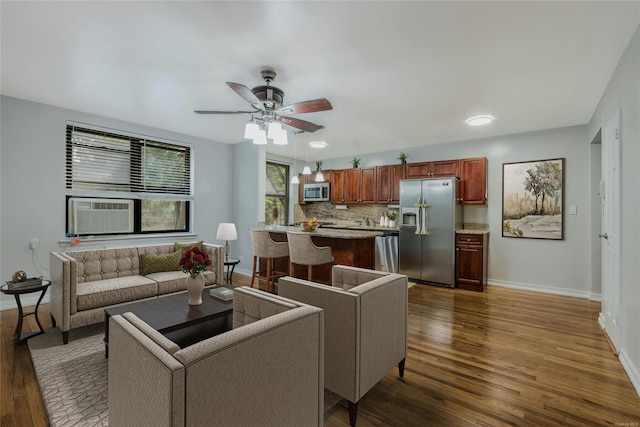 living room featuring cooling unit, ceiling fan, and dark hardwood / wood-style flooring