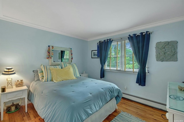 bedroom with wood-type flooring, crown molding, and a baseboard heating unit