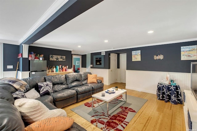 living room with crown molding and light hardwood / wood-style flooring