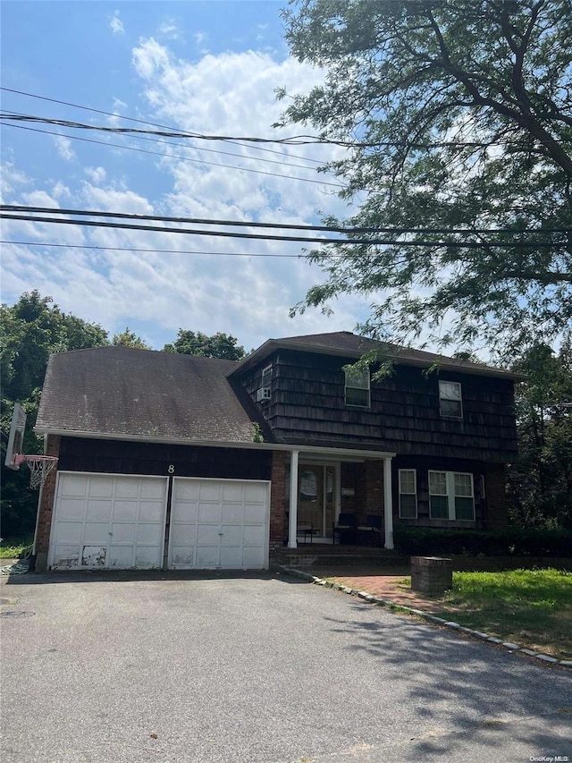 front facade featuring covered porch and a garage