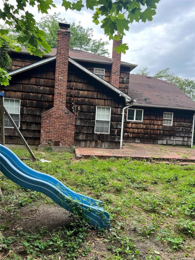 back of house with a playground