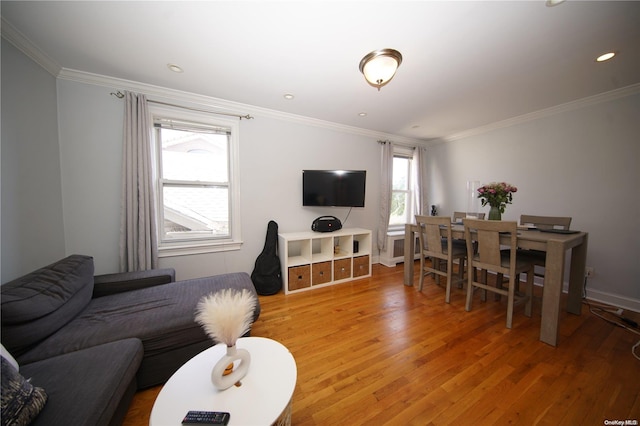 living room with crown molding, a healthy amount of sunlight, and wood-type flooring