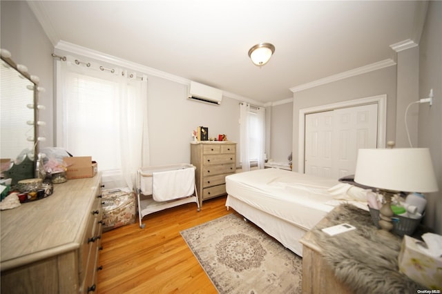 bedroom with light hardwood / wood-style floors, ornamental molding, a wall unit AC, and a closet