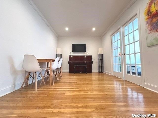 dining area with crown molding and light wood-type flooring