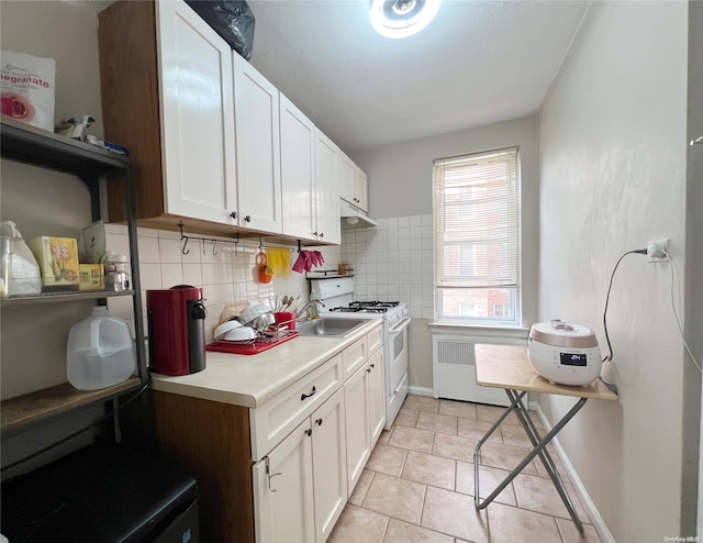 kitchen featuring tasteful backsplash, radiator, white cabinetry, and white gas range oven