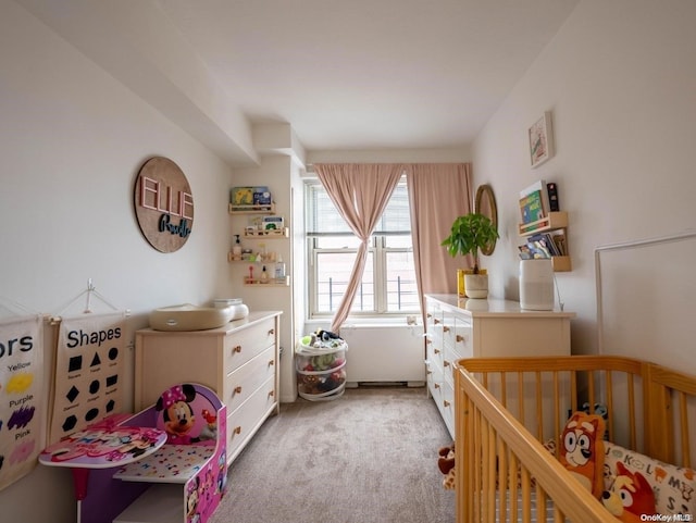 bedroom featuring a crib and light carpet