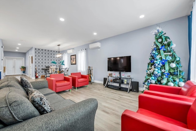 living room with a wall mounted air conditioner and light wood-type flooring