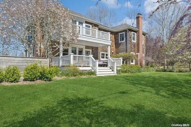 56 Cedar Point Ln, Sag Harbor, NY 11963 - rear view of house featuring a balcony, a yard, a chimney, and a deck