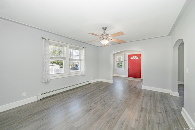 unfurnished room with baseboard heating, ceiling fan, and wood-type flooring