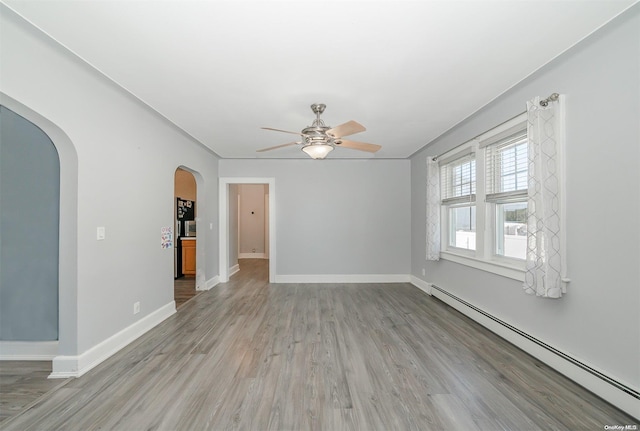 empty room with ceiling fan, light hardwood / wood-style flooring, and a baseboard radiator