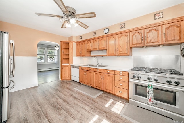 kitchen featuring light wood-type flooring, sink, appliances with stainless steel finishes, and a baseboard heating unit