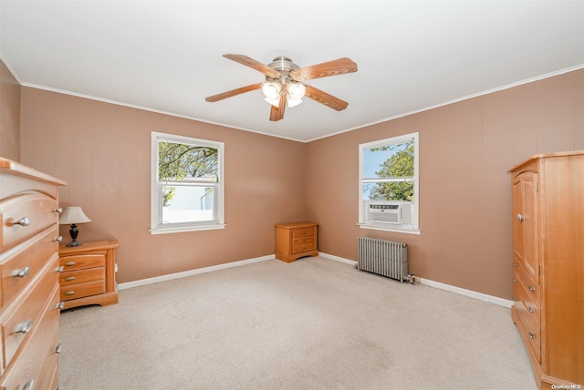 interior space featuring multiple windows, ceiling fan, radiator heating unit, and light carpet