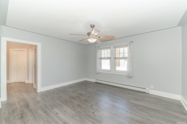 spare room with ceiling fan, hardwood / wood-style floors, and a baseboard heating unit