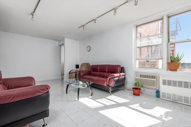 tiled living room with a wall mounted AC, radiator, and track lighting