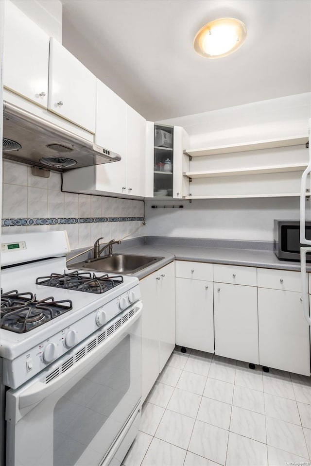 kitchen with sink, light tile patterned floors, white range with gas cooktop, decorative backsplash, and white cabinets