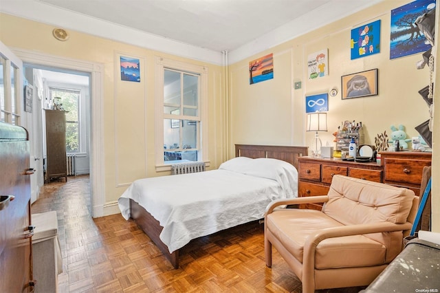 bedroom featuring radiator and parquet flooring