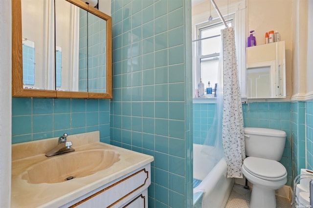 full bathroom with vanity, shower / bath combo with shower curtain, tile walls, tile patterned flooring, and toilet