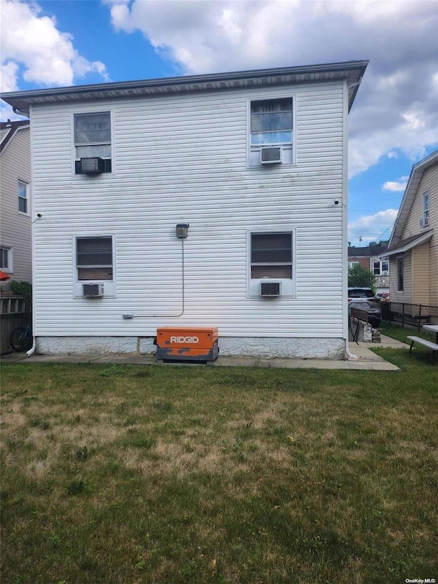 back of house with cooling unit and a lawn